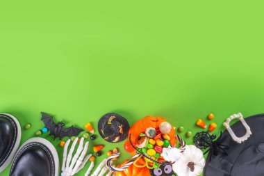 Parlak renkli Cadılar Bayramı çocukları parti aksesuarları, renkli şekerlemeler, geleneksel Cadılar Bayramı karakterleri kostümleri, şekerler, şekerler ve dekor üst görünümü ile tatil aksesuarları, şeker ya da hile