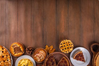 Çeşitli ev yapımı sonbahar kekleri. Geleneksel sonbahar Amerikan balkabağı, elma ve cevizli turta. Şükran Günü aile yemeği, ev yapımı pişirme ve ahşap masada hamur işi.