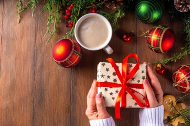 Noel, yeni yıl kış tatili hazırlığı, boş not defteri, kırmızı kurdeleli hediye kutusu, latte ya da kakao fincanı, köknar ağacı dalları ve Noel mücevherleri, kopya alanı.