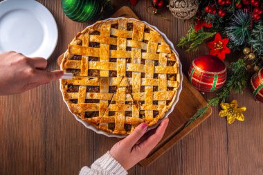 Geleneksel İngiliz Noel turtası. Ev yapımı tatlı kıymalı tart kek, baharatlı meyve, fındık ve elmalarla dolu, rahat ahşap masa üzerinde Noel ağacı ve süslemesi ile