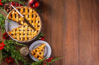 Geleneksel İngiliz Noel turtası. Ev yapımı tatlı kıymalı tart kek, baharatlı meyve, fındık ve elmalarla dolu, rahat ahşap masa üzerinde Noel ağacı ve süslemesi ile