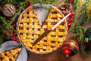 Geleneksel İngiliz Noel turtası. Ev yapımı tatlı kıymalı tart kek, baharatlı meyve, fındık ve elmalarla dolu, rahat ahşap masa üzerinde Noel ağacı ve süslemesi ile