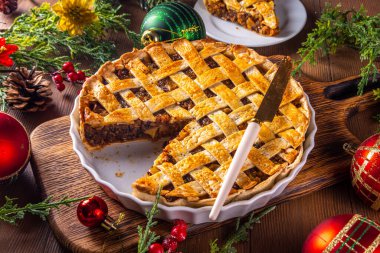 Geleneksel İngiliz Noel turtası. Ev yapımı tatlı kıymalı tart kek, baharatlı meyve, fındık ve elmalarla dolu, rahat ahşap masa üzerinde Noel ağacı ve süslemesi ile