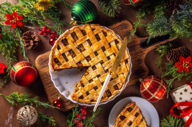 Geleneksel İngiliz Noel turtası. Ev yapımı tatlı kıymalı tart kek, baharatlı meyve, fındık ve elmalarla dolu, rahat ahşap masa üzerinde Noel ağacı ve süslemesi ile