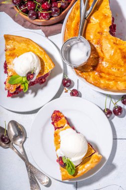 Vanilyalı dondurmalı ev yapımı vişneli pasta. Bir kepçe erimiş dondurmayla kaplı vişneli turta.