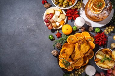 Noel ya da Yeni Yıl yemeği karanlık masada. Geleneksel Xmas parti yemekleri - pannetone, fırında tavuk, sebze, patates, peynir ve meyve tabağı, üst görünüm fotokopi alanı