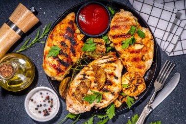 Kızarmış tavuk, hindi fileto. Baharatlı bbq kızarmış beyaz et, sarımsaklı, biberiyeli, limonlu, ketçap soslu, arka planda siyah beton masa arkaplanlı, kemiksiz fileto.