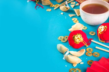 Çin 'in yeni yıl geçmişi. Geleneksel Çin Yeni Yıl dekoruna sahip kırmızı ve sarı düz yatak, dileklerle dolu zarflar, altın sikkeler, yelpazeler, Çin fenerleri, portakallar ve çay.
