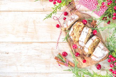  Noel şekeri, badem ezmesi ve kuru üzümle çalkalanıyor. Geleneksel Dresden İsa pastası. Köknar ağacı dalları ve Noel süslemeleri ile masa arkaplanda üst görünüm kopyalama alanı