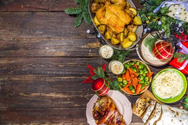 Geleneksel yiyeceklerle, fırında jambonla, tavukla, kızarmış havuçla, brunsel lahanayla, patatesle, Noel süsüsüyle ve hediyelerle dolu Noel yemeği masası. 
