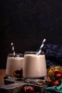 Kestane likörü. Baharatlı baharatlı kremalı içecek çırpılmış kestane, tarçın, baharat, ahşap kırsal arka planda fotokopi alanı.