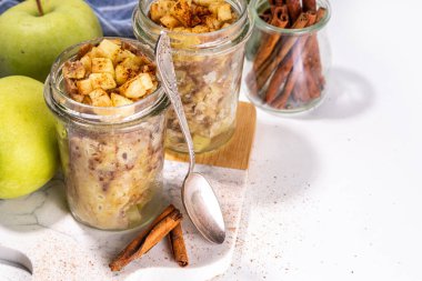 Cam kavanozda elmalı kek, mikrodalgada tarçınlı tarçınlı kek tarifi, beyaz arka planda fotokopi alanı.