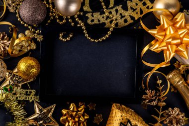 Yılbaşı partisi davetiyesi. Karnaval maskeleri, yazılı bardaklar Mutlu yıllar, arkadaşlarla ve ailelerle eğlenceli bir parti için aksesuarlar, siyah arkaplan fotokopi alanı üzerindeki Noel dekoru 