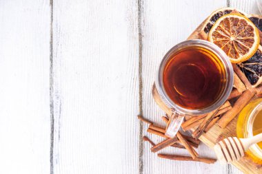 Basit tarçın, portakal ve bal çayı kupası ahşap masada malzemeler, alternatif soğuk algınlığı ilacı içecek tarifi, kopyalama alanı.