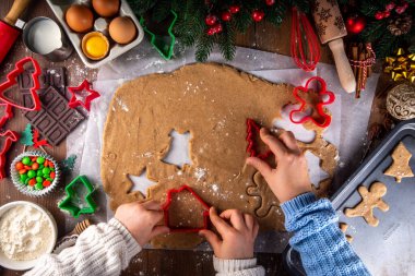 Noel kurabiyesi pişirmek aile geçmişi. Anne ve kızı rahat ahşap arka planda, kurabiye kesicili zencefilli bisküviler yapıyor, yeni yıl süslemeleri yapıyor.