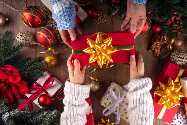 Noel hediyesi dekorasyonu. Anne ve çocuk elleri yeni yıl ve Noel hediye paketleri, bayram hazırlıkları, boks günleri. 