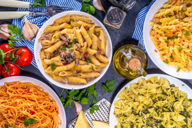 Beyaz fayanslı arka planda farklı soslu makarna seti. Spagetti, farfalle, makarna, deniz ürünleri, ıspanak, karbonara, domates soslu fusilli makarna. İtalyan yemeği, Akdeniz yemeği konsepti