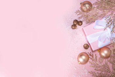 Gül sarısı Noel, yeni yıl arkaplanı altın noel ağacı dalları ve topları, bayram hediyesi kutuları, süslemeler, sanatsal kar, pembe arka plan üzerinde düz yatış fotokopi alanı