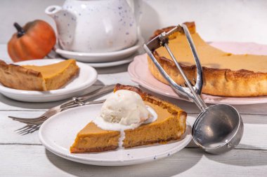 Geleneksel sonbahar balkabağı turtası. Tatlı Şükran Günü yemeği, balkabağı kabaklı mevsimlik pasta, tarçın, vanilyalı dondurma kepçeli top, ahşap arka planda