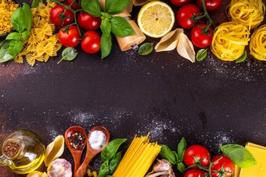 Baharatlı makarna ve yemek pişirmek için malzemeler. Hazırlık yemeği, öğle yemeği arkaplanı taze fesleğen, domates, baharat, sarımsak ve farklı çeşitte İtalyan Akdeniz makarnası.