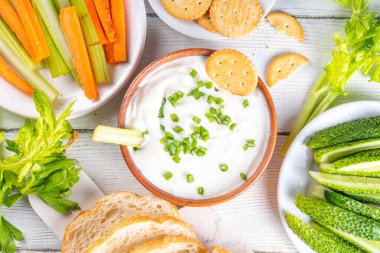 Süzme peynir yüksek proteinli sos taze sebzeler, ekmek ve krakerler ahşap masa üzerinde fotokopi alanı. Çeşitli abur cuburlarla birlikte sağlıklı peynirli diyet yemek