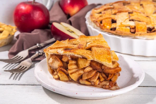 Traditional autumn apple pie. Sweet Thanksgiving dinner, fall seasonal cake with apples, cinnamon, nuts and caramel, with vanilla ice cream scoop ball, on wooden cosy background