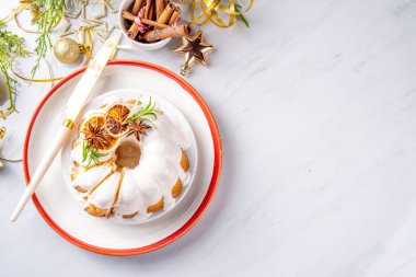 Noel pastası şekerli, portakallı ve biberiyeli. Geleneksel Noel ve yeni yıl pişirilmiş tatlı, vanilyalı meyveli kek, beyaz xmas süslemeli arka plan