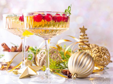 Kızılcık, portakal, baharat ve biberiyeli Noel şampanyası. Noel ve yeni yıl arkaplanda alkollü kokteyl bardakları.