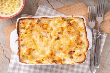 Pişirmek için malzemeli fırında makarna ve peynir. Fırında makarna güveci ve beşamel krem soslu ve peynirli makarna.
