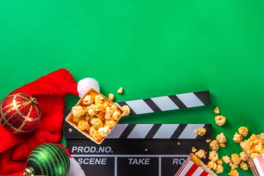 Noel filmi gecesi kısmı, ev sineması için aile ve arkadaşlarını topla. Yeni yıla davetiyeler, Noel filminin galası, Noel ağacı süslemesi, bir kova patlamış mısır, Noel Baba şapkası.