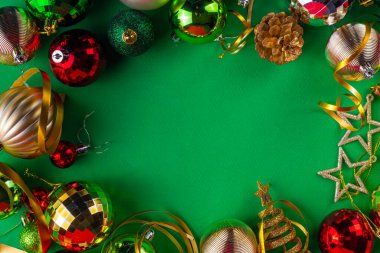 Parlak yeşil yeni yıl arkaplanı, kırmızı, yeşil, altın kostüm topları, flamalar ve süslemeler, üst görünüm fotokopi alanı. Noel ve Yeni Yıl tebrik kartı düzleştirildi