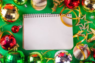 Parlak yeşil yeni yıl arkaplanı, kırmızı, yeşil, altın kostüm topları, flamalar ve süslemeler, üst görünüm fotokopi alanı. Noel ve Yeni Yıl tebrik kartı düzleştirildi