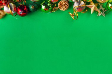 Parlak yeşil yeni yıl arkaplanı, kırmızı, yeşil, altın kostüm topları, flamalar ve süslemeler, üst görünüm fotokopi alanı. Noel ve Yeni Yıl tebrik kartı düzleştirildi