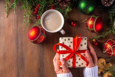 Noel, yeni yıl kış tatili hazırlığı, boş not defteri, kırmızı kurdeleli hediye kutusu, latte ya da kakao fincanı, köknar ağacı dalları ve Noel mücevherleri, kopya alanı.