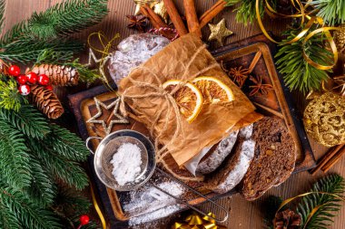 Ev yapımı Noel çikolatası çalınmış. Geleneksel Aralık tatili, yeni yıl ve Noel pişmiş tatlı tatlı, kurutulmuş meyve ve fındıklı koyu çikolatalı pasta, samimi Xmas dekorasyonlu arka plan