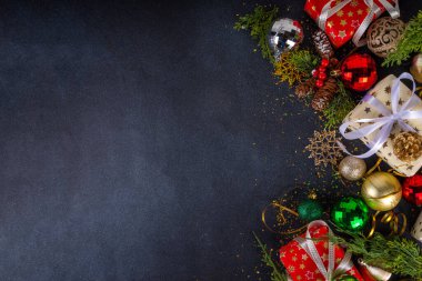 Noel ve yeni yıl tebrik kartı geçmişi, bayram kurdeleli hediye kutuları, noel ağacı dalları, altın, kırmızı, yeşil bayram dekoru, takılar ve kostüm ağacı topları, üst görünüm kopyalama alanı