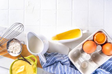 Malzemeli ev yapımı krema. Vanilya, süt ve yumurta. Tatlı krema beyaz mutfak masasının fotokopi masasında tatlı pişirme arkaplanı. 