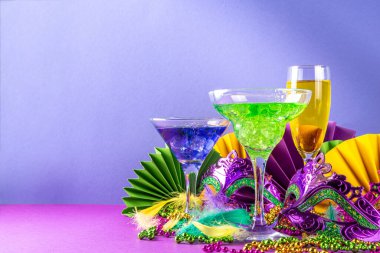 Mardi Gras kokteylleri hazır. Renkli mor, sarı, yeşil martini şampanya Mardi Gras parti barı için şarap bardakları karnaval dekorlu ve Orleans maskeli