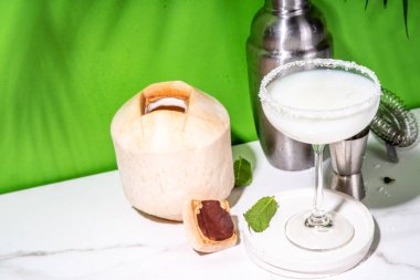 Hindistan cevizli daiquiri ya da martini kokteyli, kremalı likör ve genç hindistan cevizi suyu, renkli arka planda.