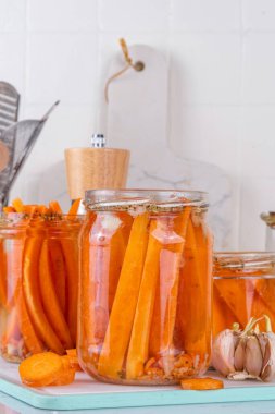 Ev yapımı havuç turşusu, fermente edilmiş havuç, mutfak masasındaki cam kavanozlarda saklanmış konserve sebzeler.