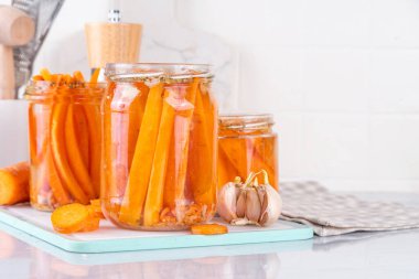 Ev yapımı havuç turşusu, fermente edilmiş havuç, mutfak masasındaki cam kavanozlarda saklanmış konserve sebzeler.
