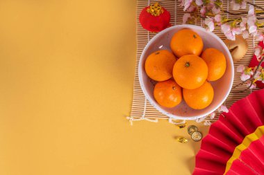 Kopya alanı olan Çin Yeni Yıl temalı arka plan. Kırmızı fanlar, altın sikkeler, mandallar, kiraz çiçekleri, bayram altın dalları, dekorlar, dilek zarfları. Altın arka planda altın ejder 