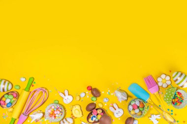 Yüksek renkli Paskalya pastası arka planı, Paskalya indirimi, parti davetiyesi deri yüzme, renkli Paskalya yumurtaları, çikolata yumurtaları ve parlak sarı arka plan manzaralı şeker parçacıklı tavşan fotokopi alanı