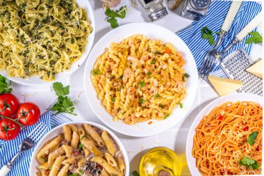 Beyaz fayanslı arka planda farklı soslu makarna seti. Spagetti, farfalle, makarna, deniz ürünleri, ıspanak, karbonara, domates soslu fusilli makarna. İtalyan yemeği, Akdeniz yemeği konsepti