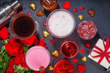 Valentine day romantic bar background. Set various red, pink, chocolate alcohol drinks for Valentine day party or dating, in different cocktail glasses with rose flower bouquet, heart decor, gift box