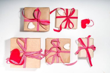 Sevgililer Günü tebrik kartı geçmişi. Çeşitli sevgililer günü hediye kutuları, el işi, kalp, kırmızı kurdele, beyaz arka planda.