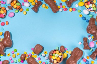 Easter chocolate egg and bunny background. High-colored flat lay with chocolate bunny and rabbits, colorful chocolate eggs. Preparation for Easter, greeting card, Easter sale, top view copy space