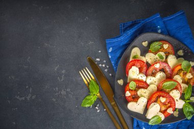 Sevgililer Günü yemeği için Caprese salatası, domates, kalp şeklinde peynir, fesleğen. Sevgililer Günü menüsü konsepti üst görünüm kopyalama alanı