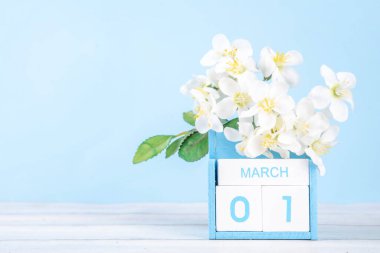 Tahta takvim ve açık mavi arkaplan üzerinde bahar çiçeği olan bahar tatili arka planı fotokopi alanı