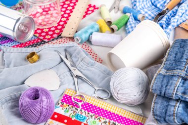 DIY fikirler ve materyal arka planı geliştiriyor. El yapımı sürdürülebilir hobi, plastik şişeler, metal kutular, eski kotlar, kumaşlar, cam kaplar, üst görünüm ile yeniden kullanılabilir ekoloji yaratıcı el yapımı